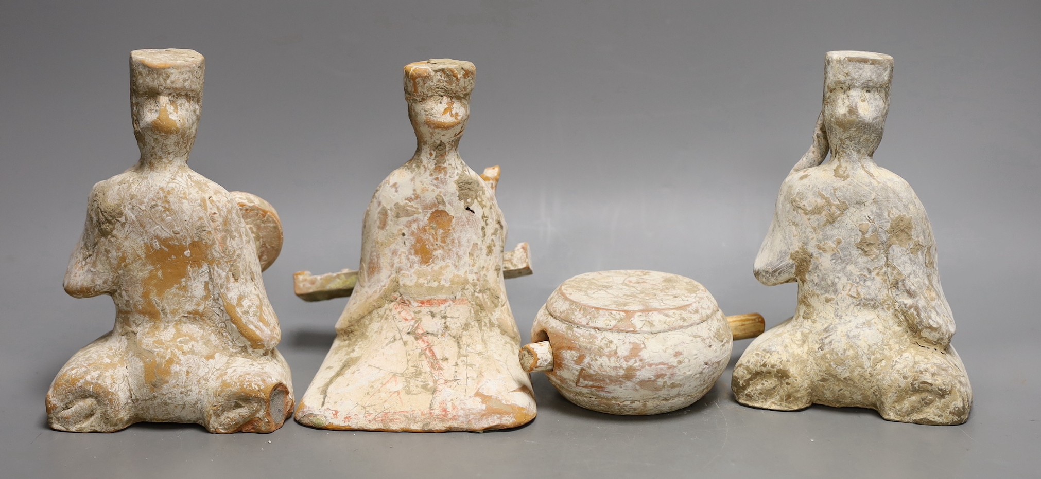 Three Chinese painted pottery figures of musicians and a model drum, Tang dynasty or later, 18.5cms high